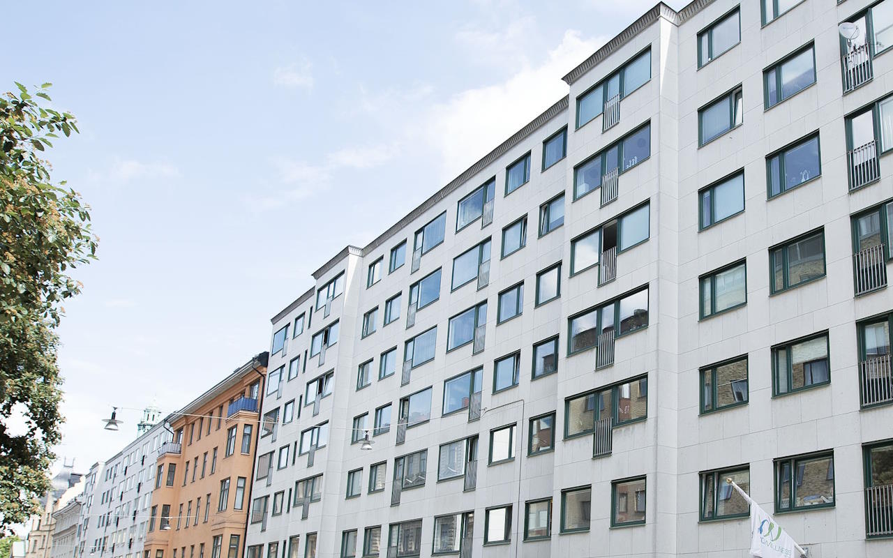 fönsterna på detta flerbostadshus skapar en stämningsfull kontrast gentemot fasadens material och färgval detta är en utav anledningarna till att bygglov ofta krävs även när det gäller just färgerna vid ett fönsterbyte för visst håller du med vita karmar och fönsterbågar hade inte gett samma intryck